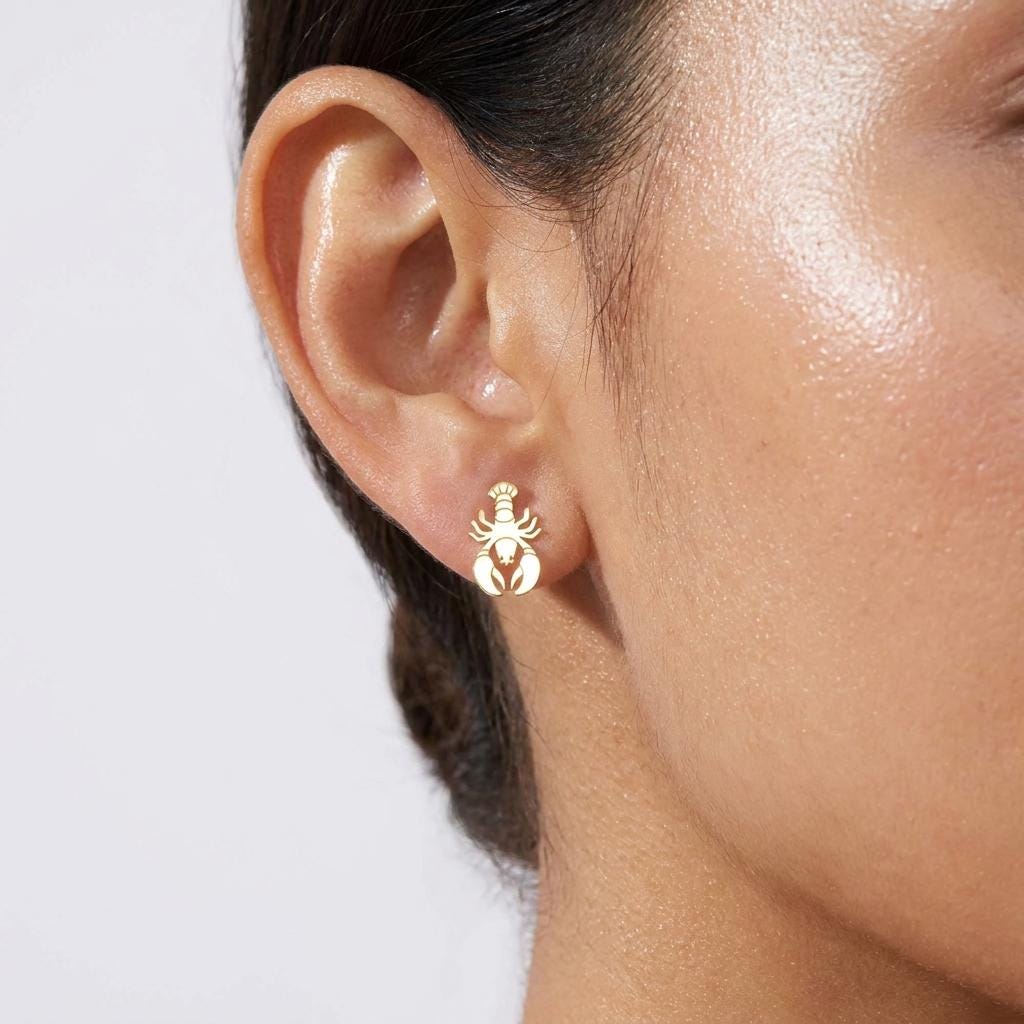 Pair of gold lobster stud earrings with raised claws and segmented tail