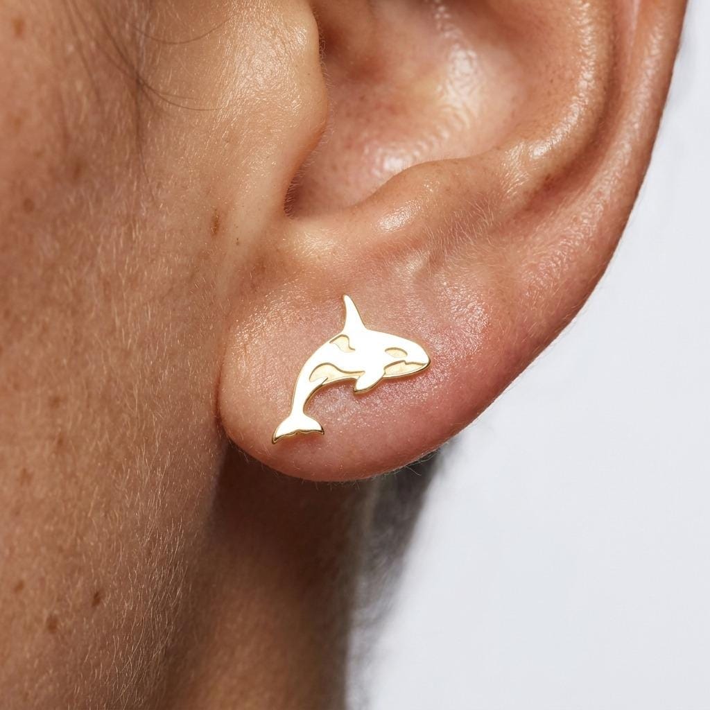 Pair of small orca whale stud earrings in gold, shown in side profile (2 of 6)