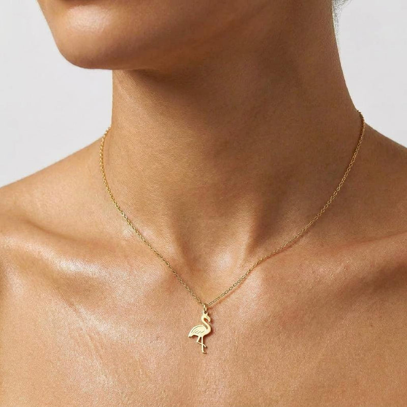 Tiny gold flamingo pendant with curved neck on a fine chain