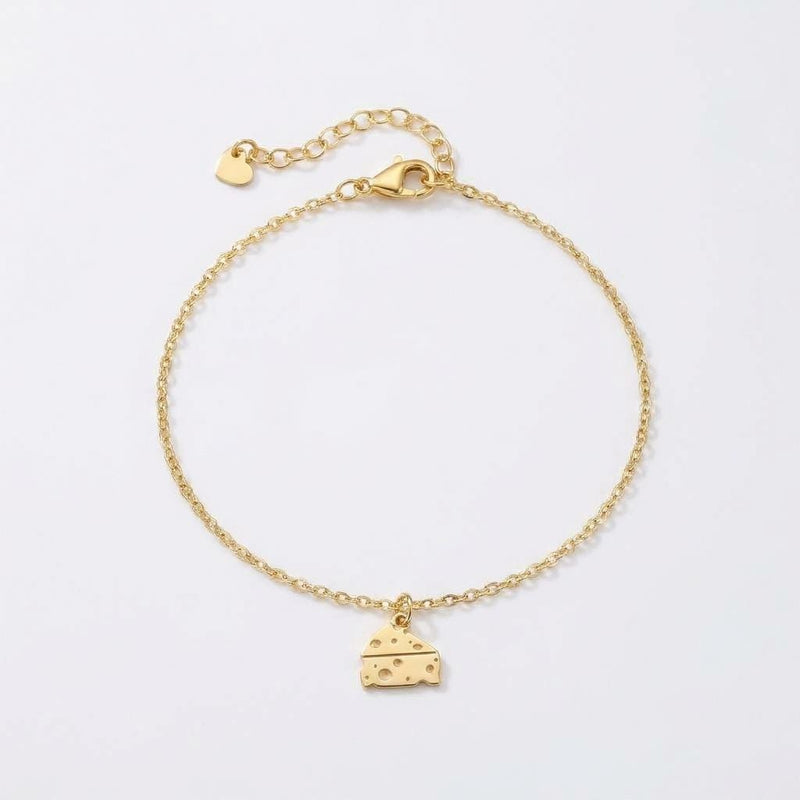 Fine gold bracelet chain with a small cheese wedge charm showing round holes