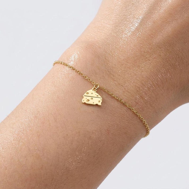 Fine gold bracelet chain with a small cheese wedge charm showing round holes (2 of 6)