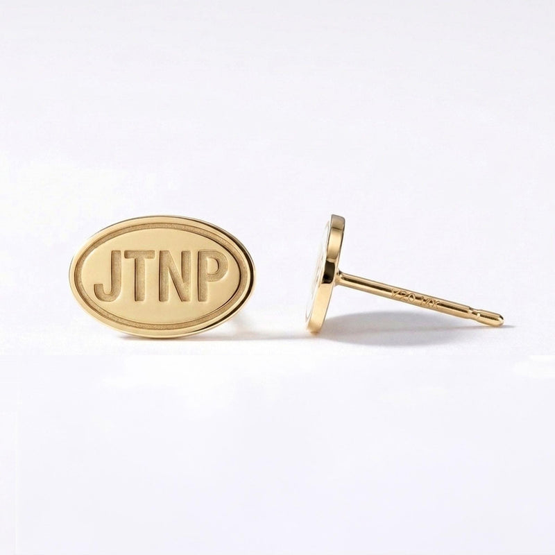 Pair of small gold oval stud earrings showing a Joshua tree and desert horizon