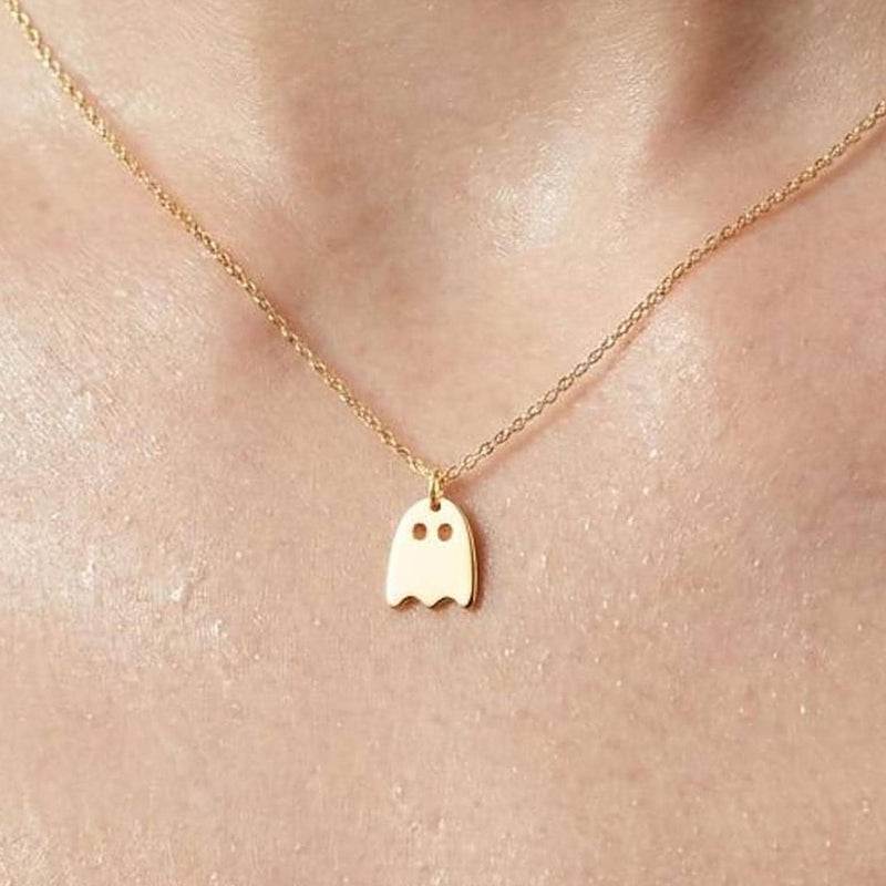 Small gold ghost pendant with a wavy hem hanging from a fine cable chain