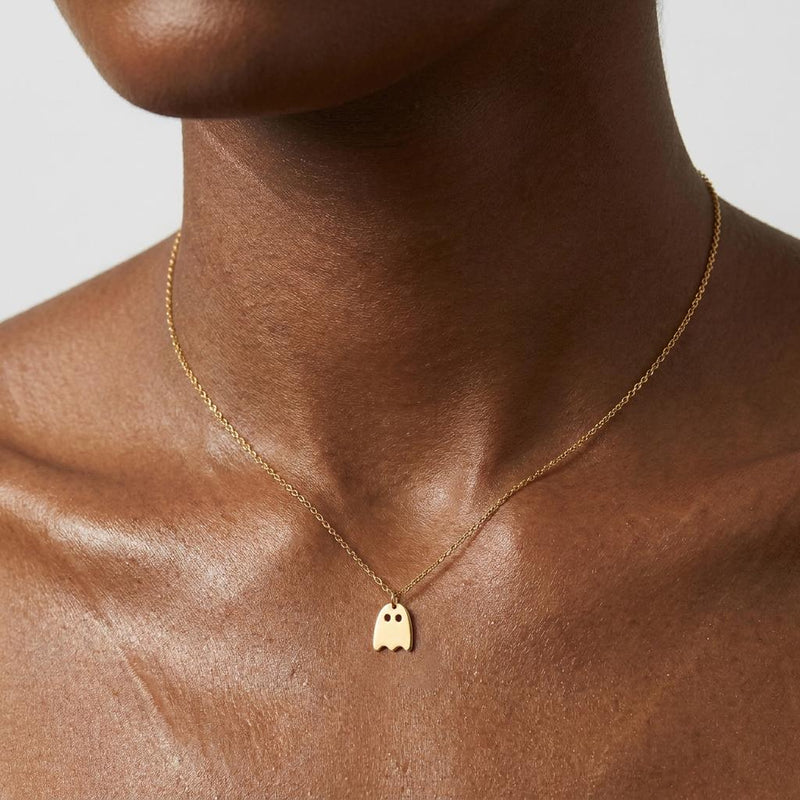 Small gold ghost pendant with a wavy hem hanging from a fine cable chain (3 of 9)