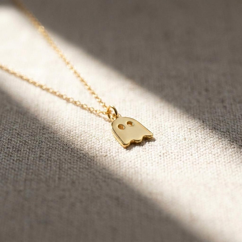 Small gold ghost pendant with a wavy hem hanging from a fine cable chain (5 of 9)