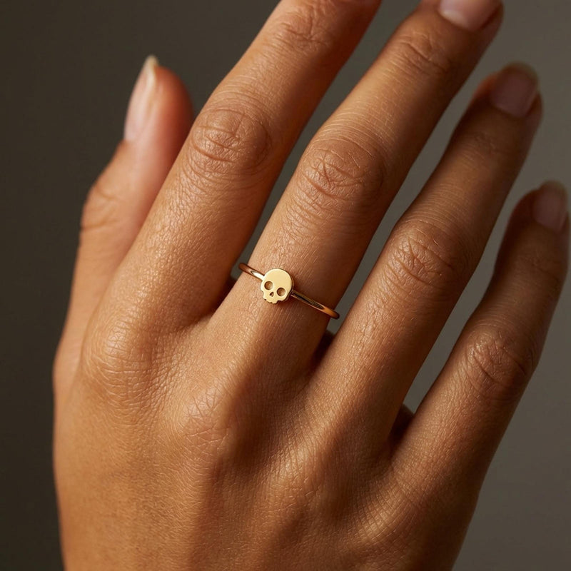Thin gold ring set with a small skull charm with cut eye sockets and a grin (3 of 11)