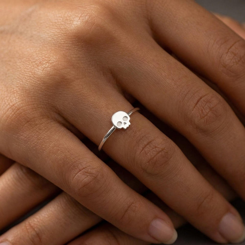 Thin gold ring set with a small skull charm with cut eye sockets and a grin (4 of 11)