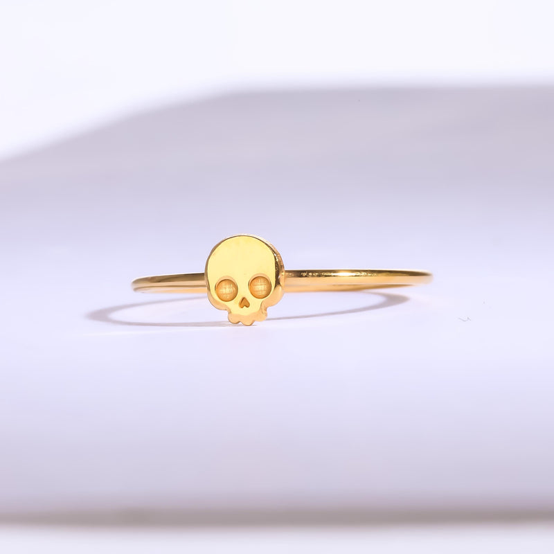 Thin gold ring set with a small skull charm with cut eye sockets and a grin (6 of 11)