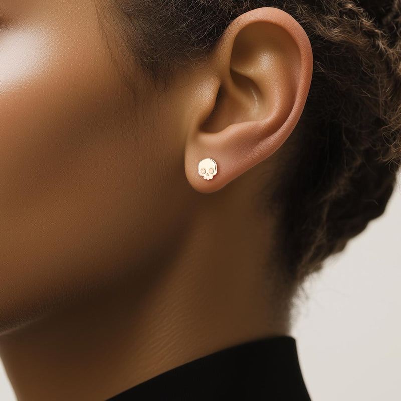 Pair of tiny gold skull stud earrings with round eye sockets (12 of 12)