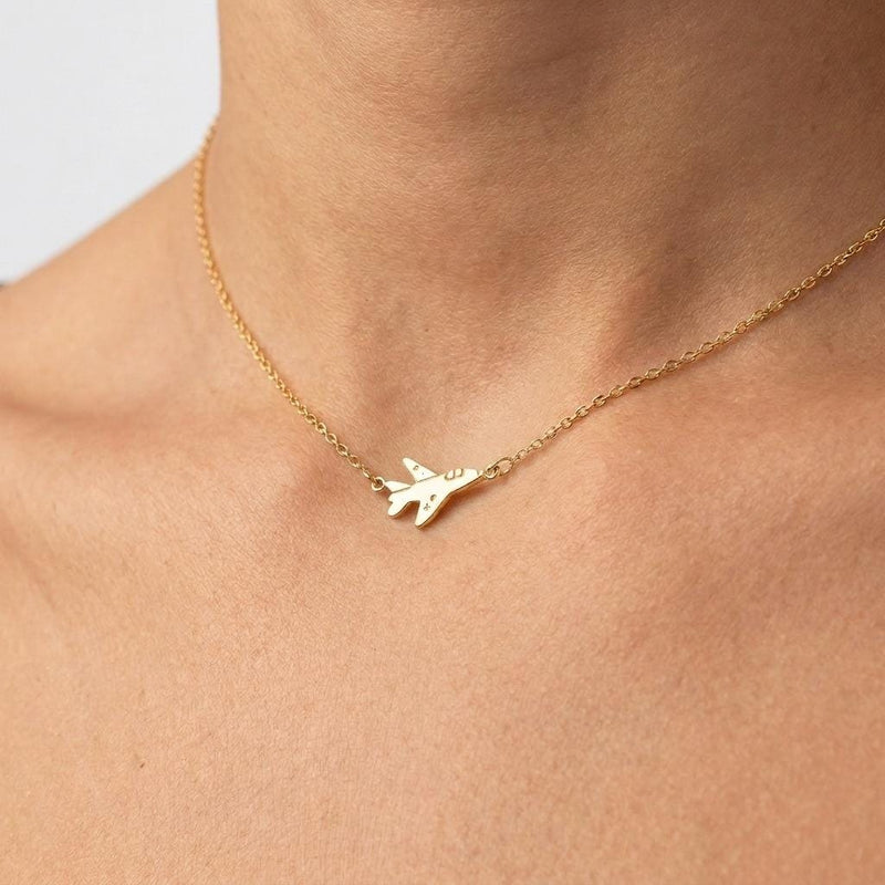 Small gold fighter jet pendant with swept wings on a fine cable necklace chain