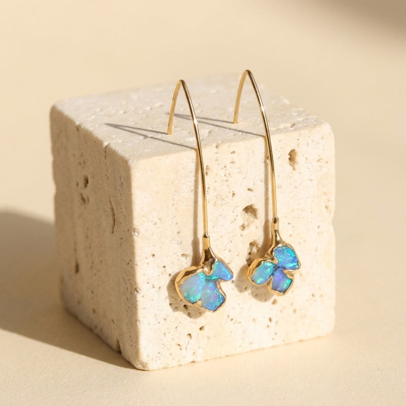 Edgy Raw Opal Dangle Earrings on a travertine block