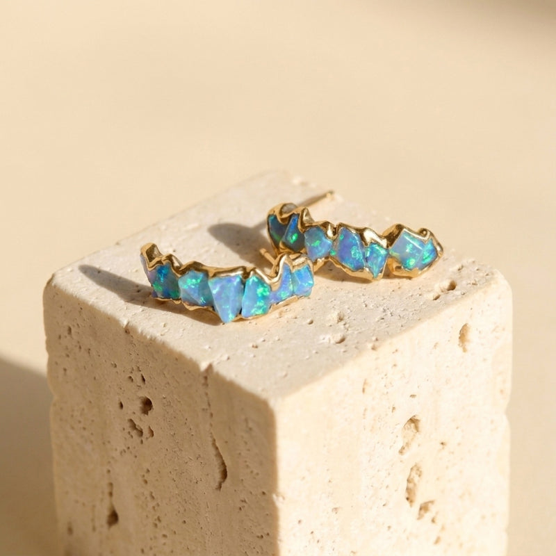 Raw Opal Half Hoop Cluster Earrings on a travertine block