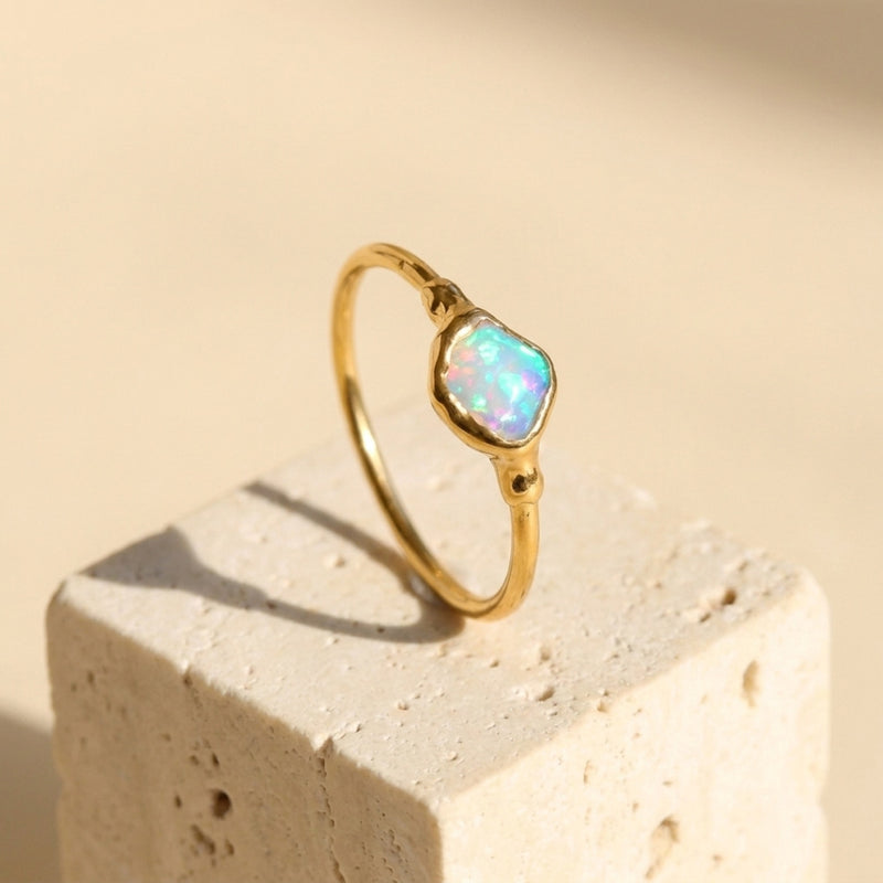 Mini Raw Australian Opal Ring on a travertine block