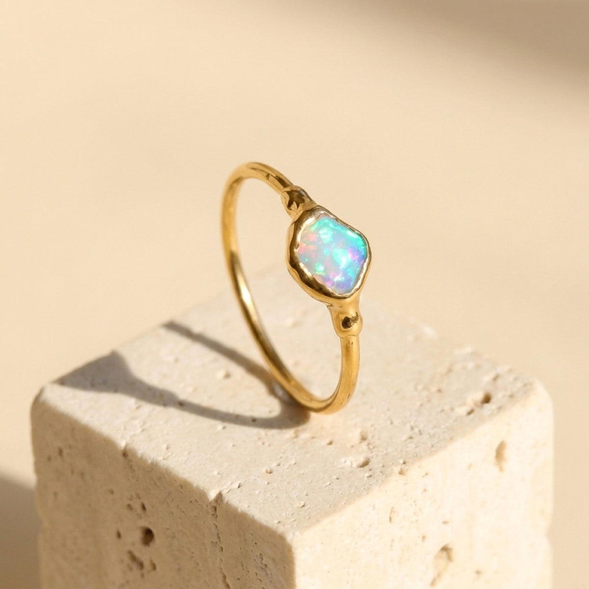 Mini Raw Australian Opal Ring on a travertine block