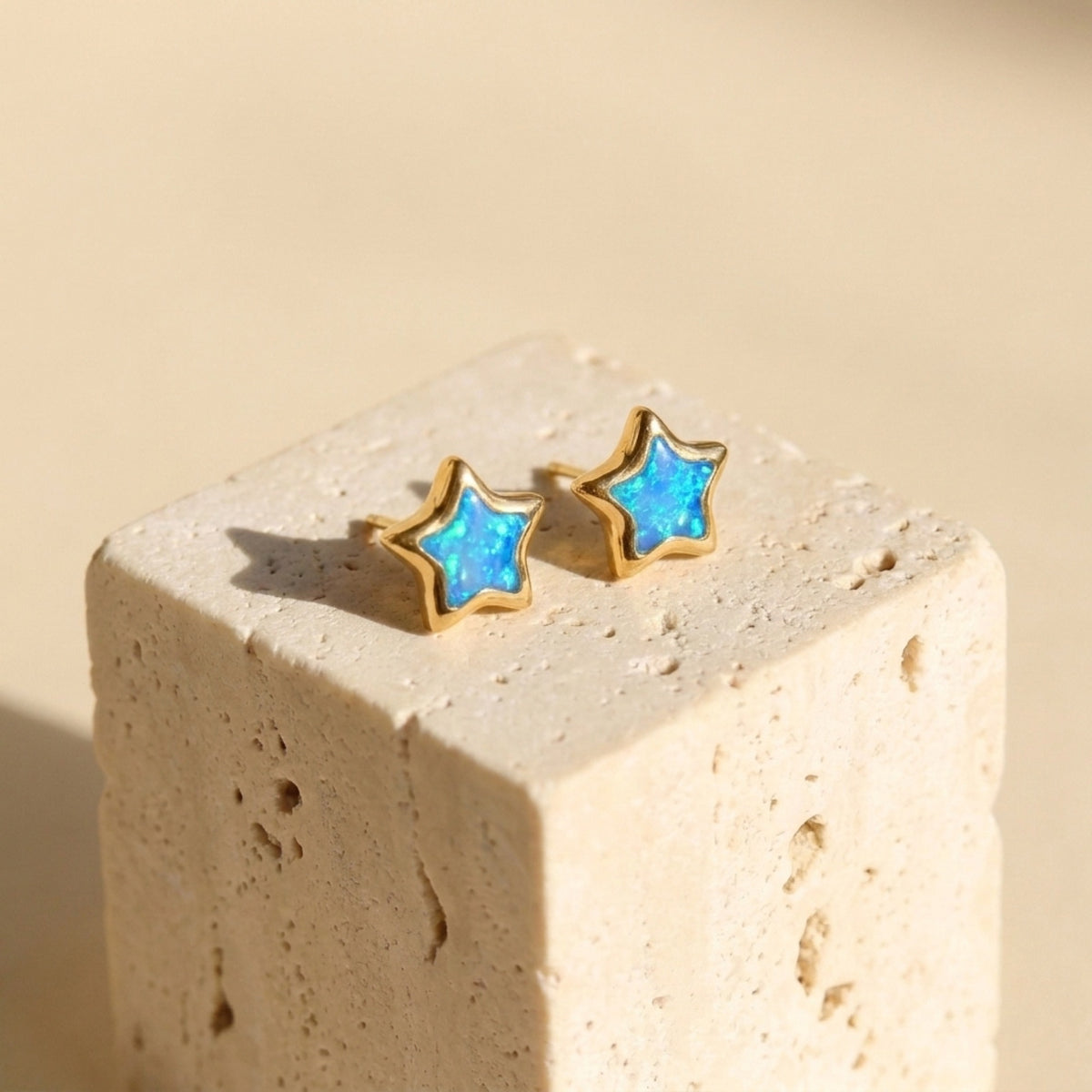 Dainty Star Kyocera Opal Stud Earrings on a travertine block