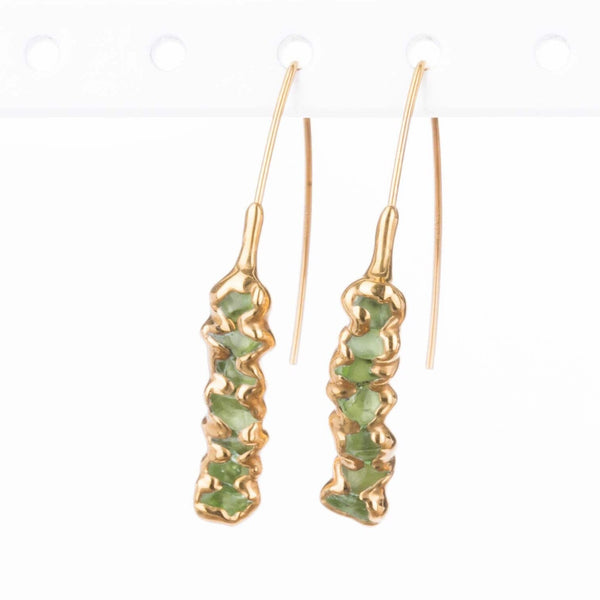 Raw Peridot Dangle Earrings on a white background