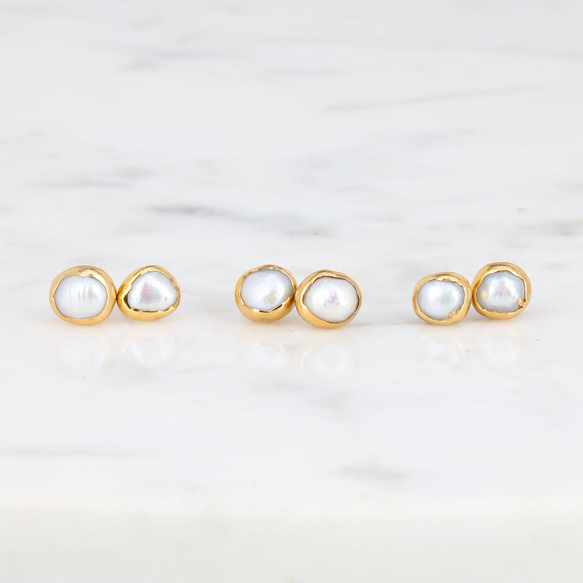 Mini Pearl Stud Earrings on a white background