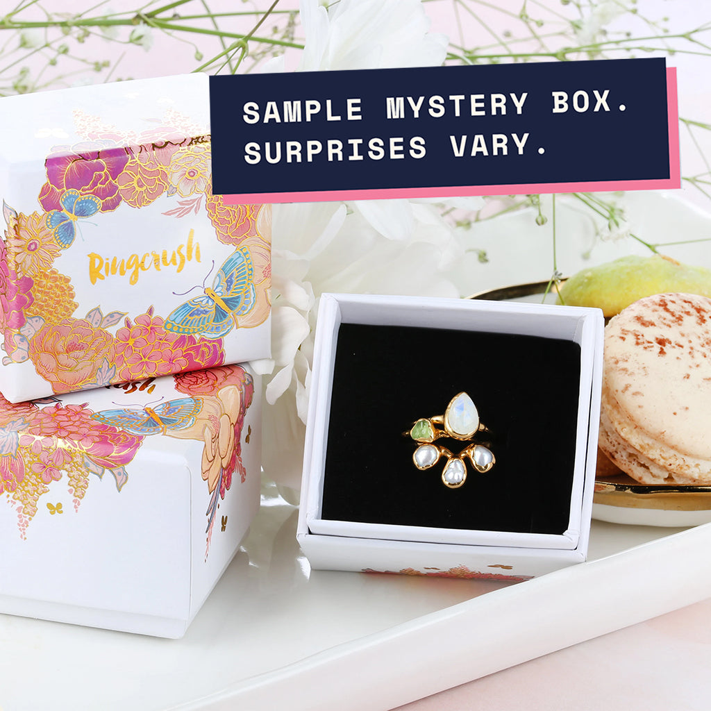 Sample Ringcrush ring mystery box with a stack of raw gemstone rings
